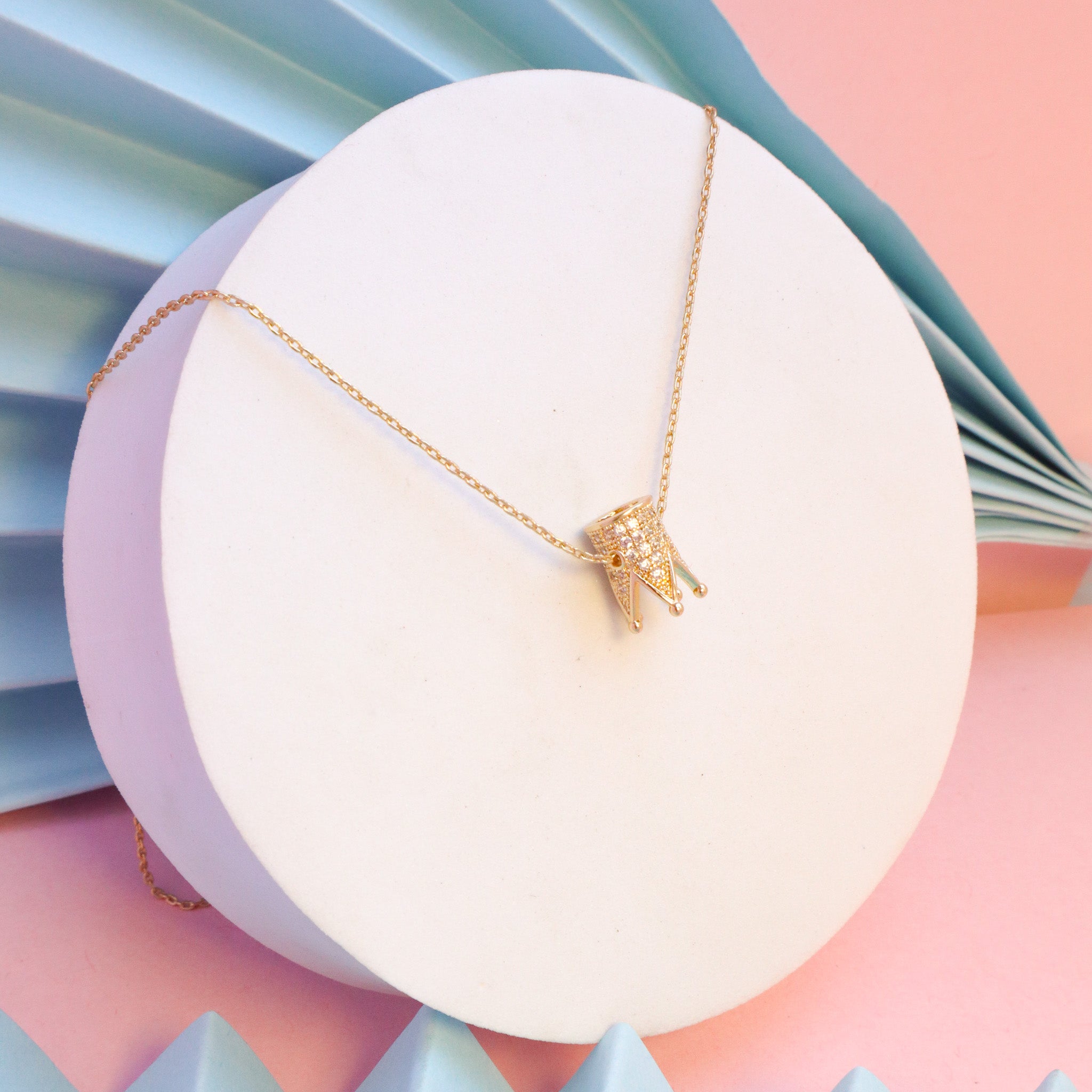 A gold necklace with a crown on it photo – Free Dubai - united arab  emirates Image on Unsplash